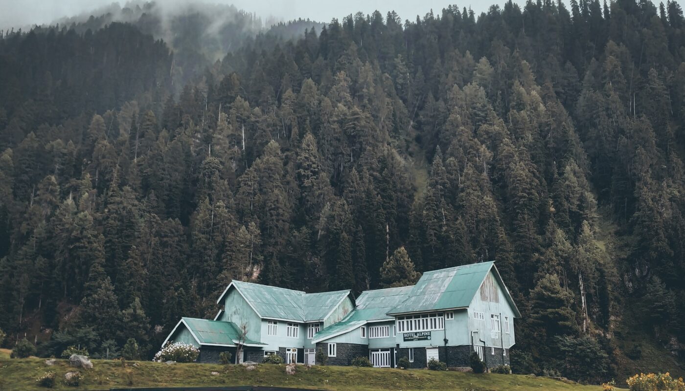 green and white house near green trees during daytime